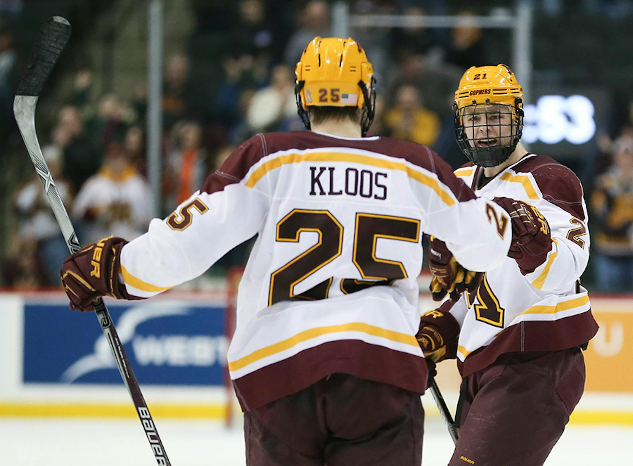 Gophers forward Connor Reilly (21) was congratulated on his game-tying goal in the third period by teammate Justin Kloos (25)Sunday afternoon.