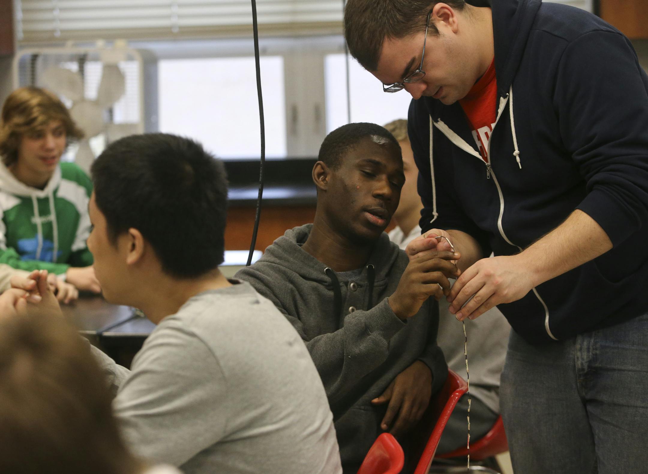 Coon Rapids High biology teacher Nathan Hoekstra, right, talks with Beresford Jimmy, a junior, who was among those in class making a model of folding proteins at Coon Rapids High Thursday, Feb. 20, 2014, in Coon Rapids, MN.(DAVID JOLES/STARTRIBUNE) djoles@startribune.com While Minnesota and other large school districts struggled to lessen the disparity between white and minority students proficiency in reading and math, Anoka-Hennepin, including Coon Rapids High, surpassed goals set by the state