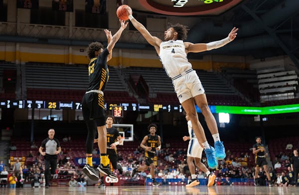 Totino-Grace’s Isaiah Johnson-Arigu (right) blocks the shot of DeLaSalle’s Jaden Morgan in the first half of the Class 3A semifinals Thursday at W