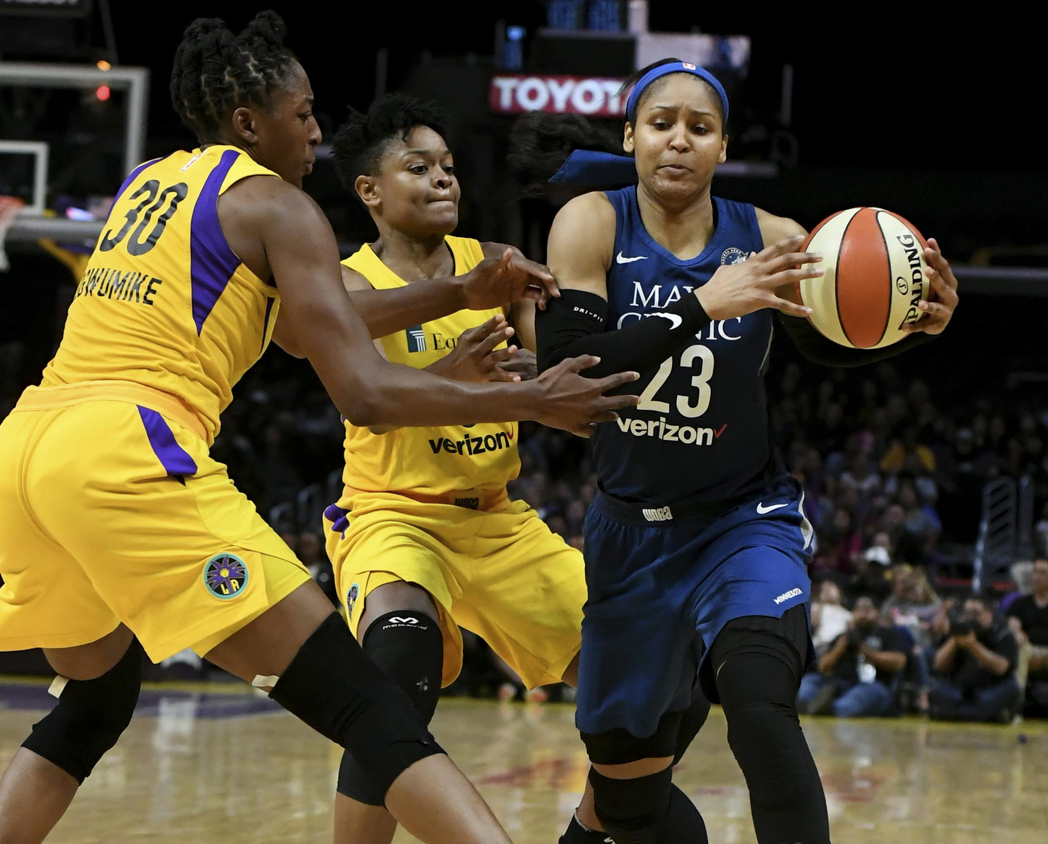 Minnesota Lynx forward Maya Moore (23) controls the ball against Los Angeles Sparks' Nneka Ogwumike (30) and Alana Beard in the second half of a single elimination WNBA basketball playoff game, Tuesday, Aug. 21, 2018, in Los Angeles. The Sparks won 75-68. (Keith Birmingham/The Orange County Register via AP)