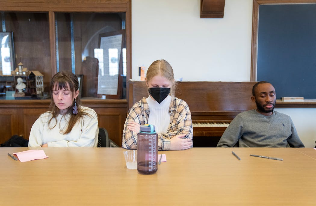 St. Olaf students Kayle Gruenes, Grace Tillmann and Dick Nchang meditate at the end of a 