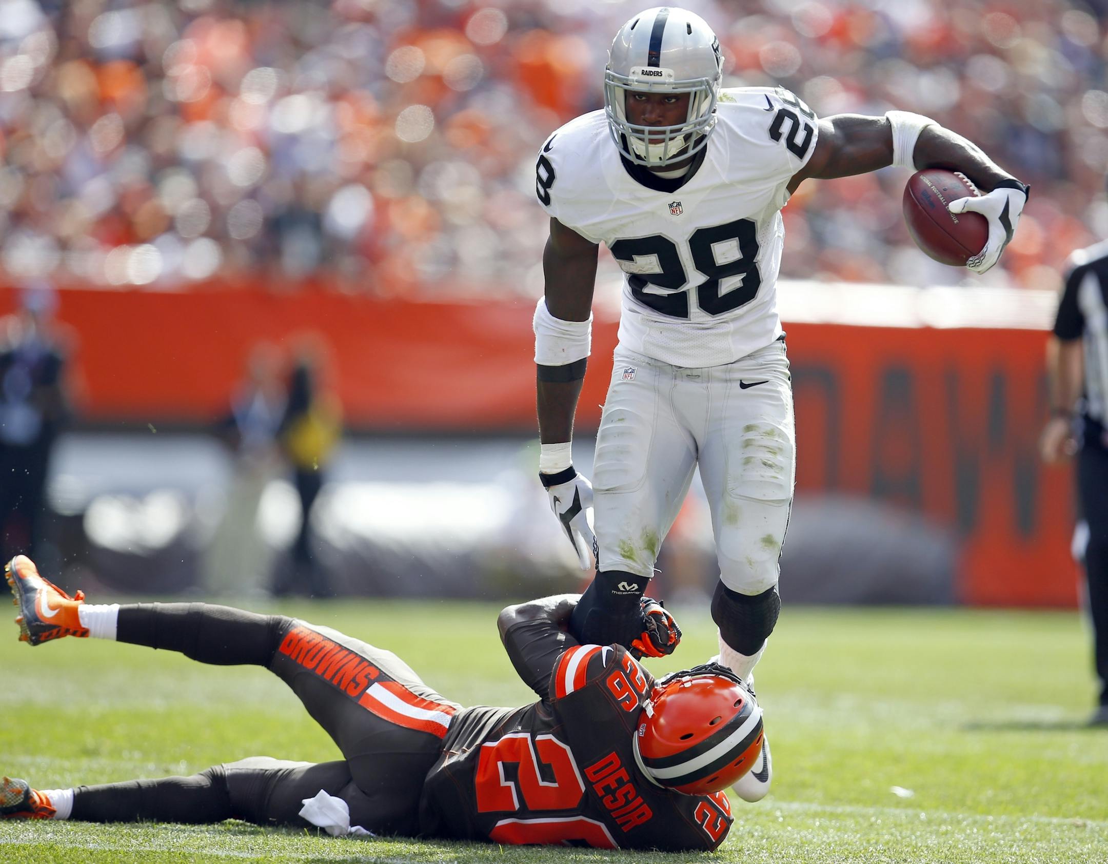 Oakland Raiders running back Latavius Murray (28) tries to avoid Cleveland Browns cornerback Pierre Desir (26) during an NFL football game in Cleveland, Sunday, Sept. 27, 2015. (Jeff Haynes/AP Images for Panini) ORG XMIT: MIN2015111320065212