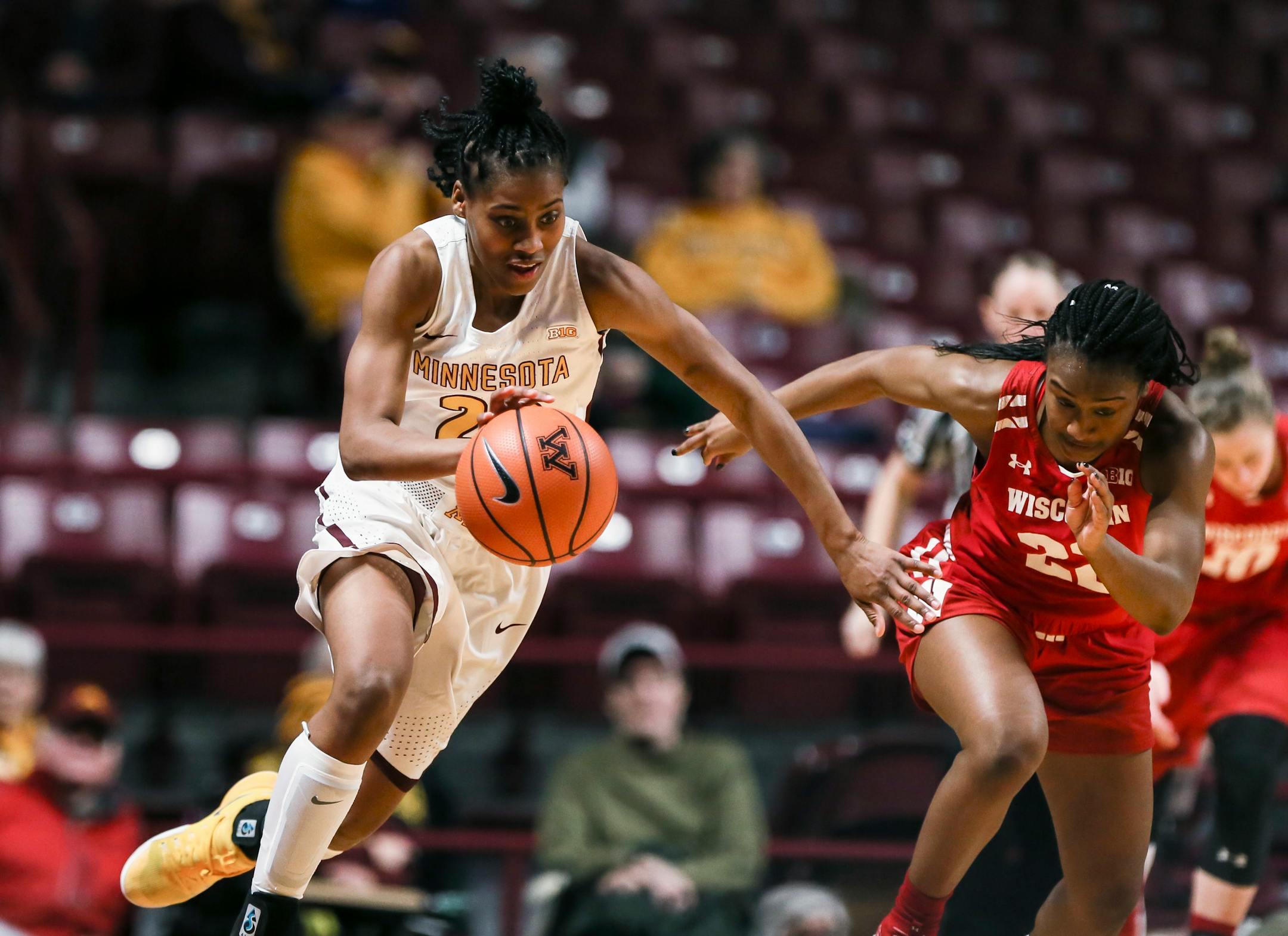 Minnesota guard Kenisha Bell (23) brings the ball up after stealing a pass intended for Wisconsin guard Niya Beverley (22) during the first half