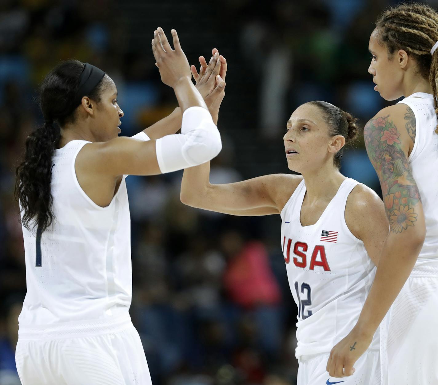 United States' Diana Taurasi, center, celebrates with teammates Maya Moore, left, and Brittney Griner, right, during a quarterfinal round basketball game at the 2016 Summer Olympics in Rio de Janeiro, Brazil, Tuesday, Aug. 16, 2016. (AP Photo/Charlie Neibergall)