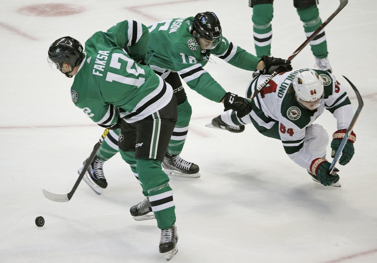 The Dallas Stars' Radek Faksa (12) and Jason Dickinson (16) steer the puck away from the Minnesota Wild's Mikael Granlund (64) at the American Airline