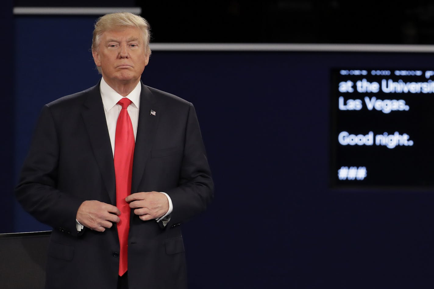 Republican presidential nominee Donald Trump buttons his jacket after the second presidential debate at Washington University in St. Louis, Sunday, Oct. 9, 2016.