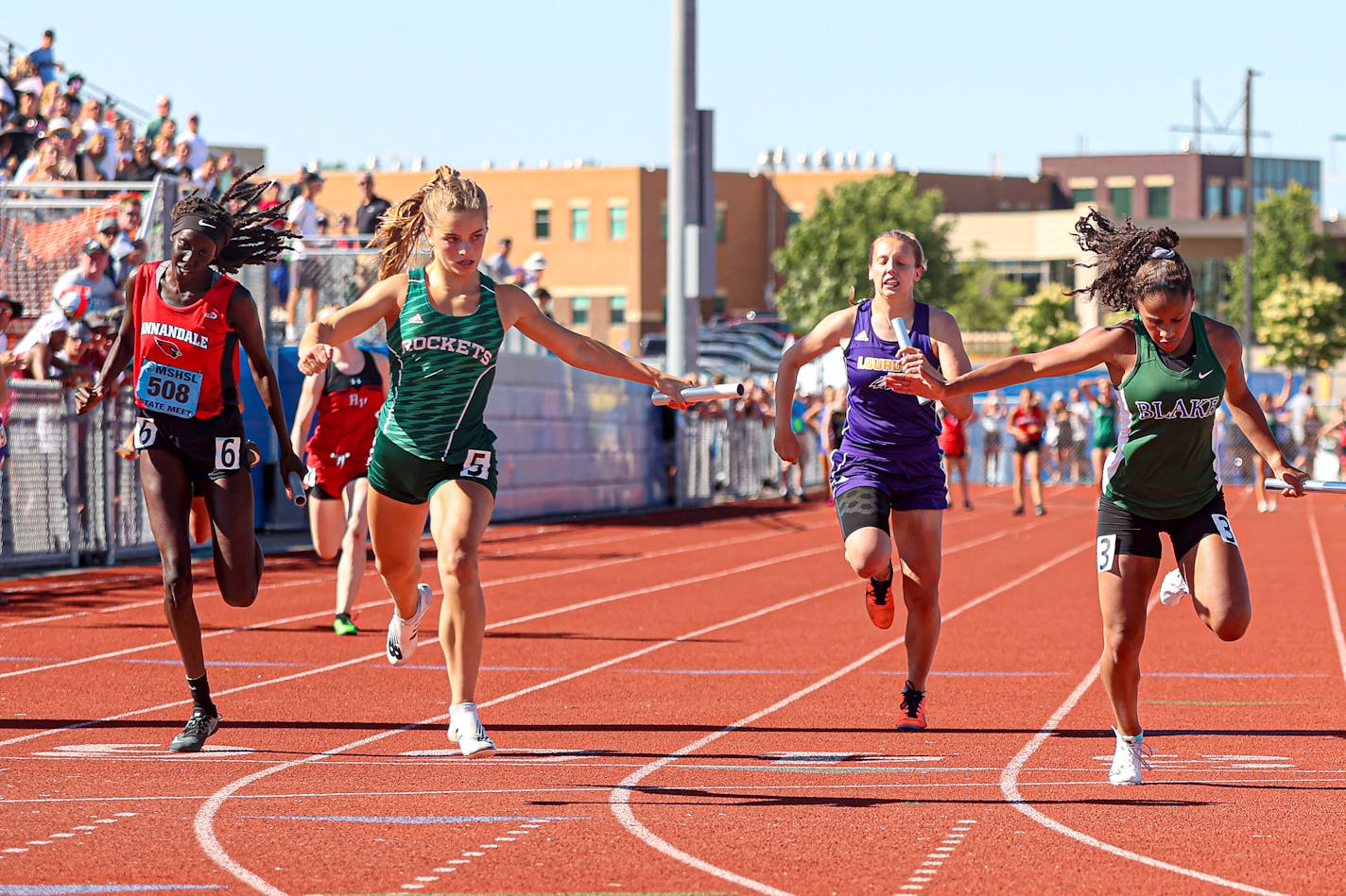 Rockford's Cassia Cady (5) crosses the finish line just ahead of Blake's Anisa Thompson (3) to give the Rockets a victory in the 4x100 relay at the girls' Class 1A state track meet. Photo by Mark Hvidsten, SportsEngine