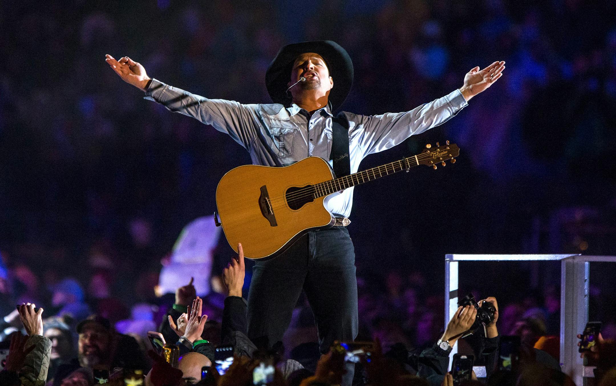FILE - In an Oct. 20, 2018 file photo, Garth Brooks performs before a sold-out crowd at Notre Dame Stadium, in South Bend, Ind. Bad weather tested the devotion of 84,000 fans who went to see Garth Brooks at Notre Dame Stadium over the weekend. Brooks also had to sing through rain and some snow. (Robert Franklin/South Bend Tribune via AP, File)