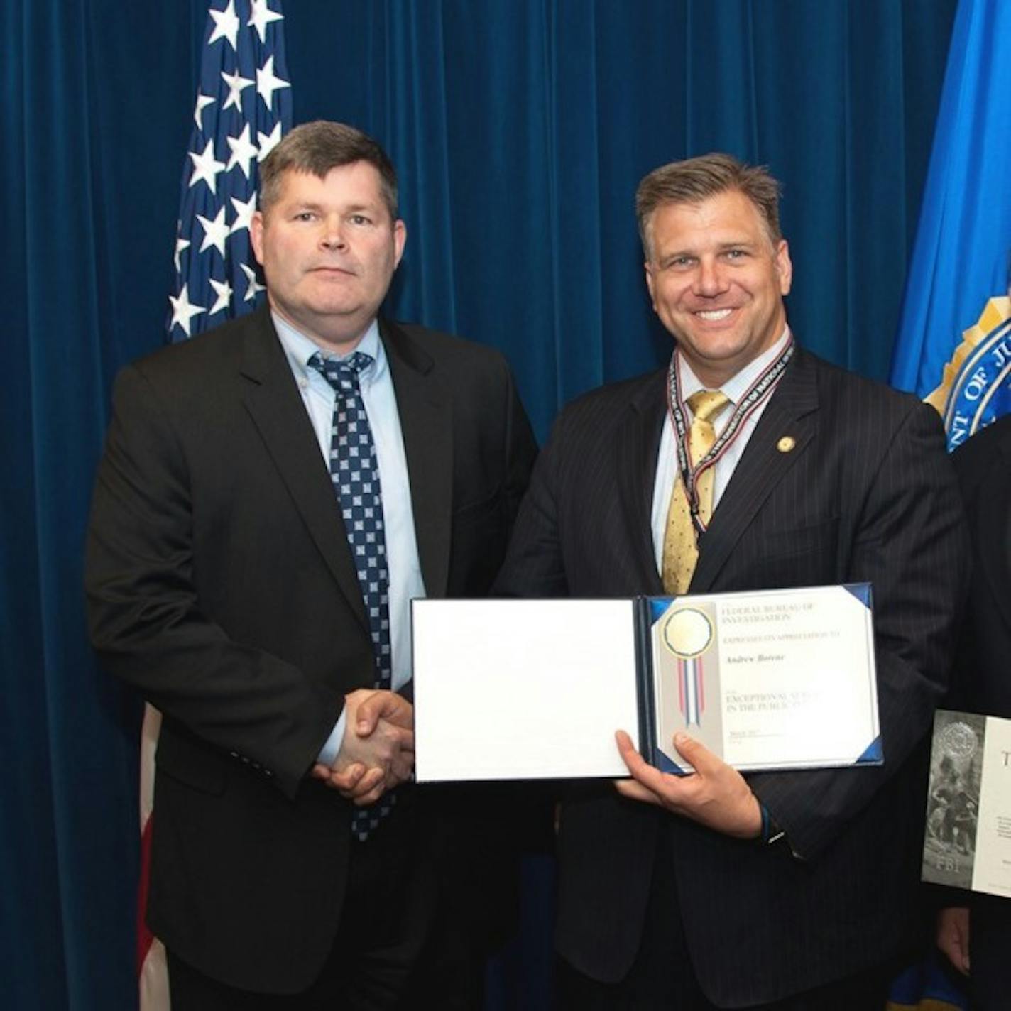 Matt Gorham, a special agent supervisor at the FBI's Washington Field Office, presents an award to Andrew Borene, an Edina native and cyber-security consultant.