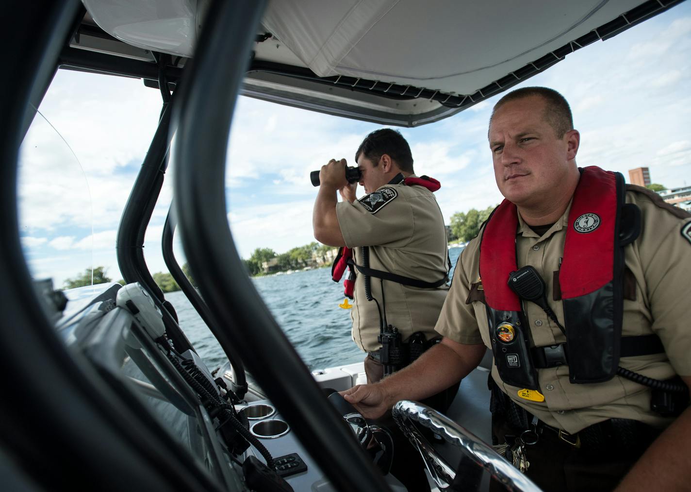 Hennepin County Sheriff's Office special deputy Amir Gharbi, left, used binoculars to look for possible boater infractions on the water as deputy Jeremy Gunia steered their boat during a patrol of Lake Minnetonka Saturday afternoon. ] (AARON LAVINSKY/STAR TRIBUNE) aaron.lavinsky@startribune.com We do a ride along with the Hennepin County Sheriff's Office Water Patrol, one of the largest such patrols in the country, as deputies patrol Lake Minnetonka on the final big boating weekend of the season