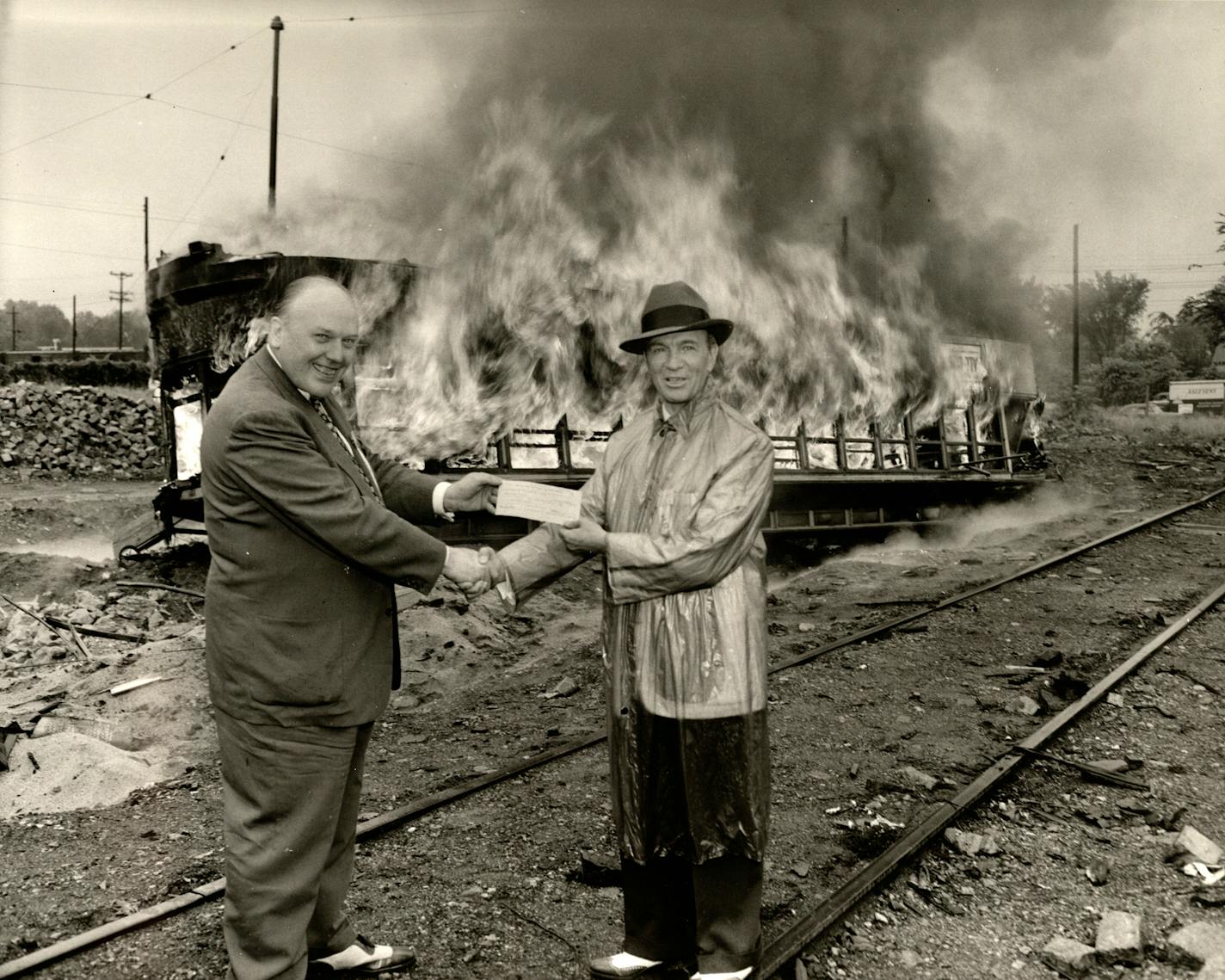 On the last day of streetcar service in 1954, Twin City Rapid Transit executives James Towey and Fred Ossanna hold a check from Northern States Power Company for the main streetcar power plant, according to "Twin Cities by Trolley." Both men were charged in the subsequent fraud case, but Towey avoided trial due to health problems.