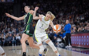 Lynx forward Bridget Carleton (6), left, and Wings guard Paige Bueckers (5) battle on the court during the first quarter as the Minnesota Lynx take on