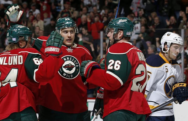 Nino Niederreiter (22) celebrated with teammates Mikael Granlund (64) and Thomas Vanek (26) after scoring his second goal of the first period. ] CARLO