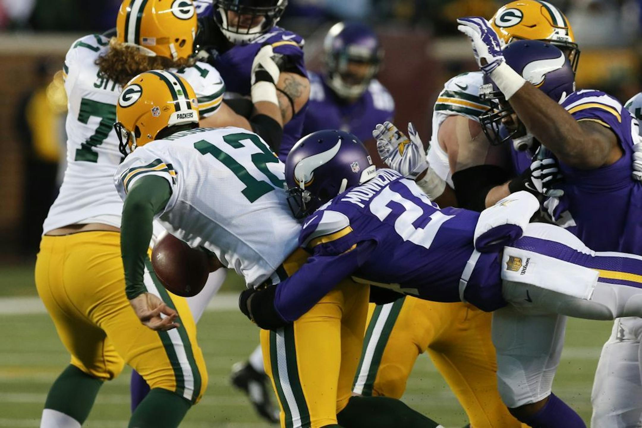 Green Bay Packers quarterback Aaron Rodgers (12) is sacked by Minnesota Vikings cornerback Captain Munnerlyn (24) during the first half of an NFL football game in Minneapolis, Sunday, Nov. 22, 2015.