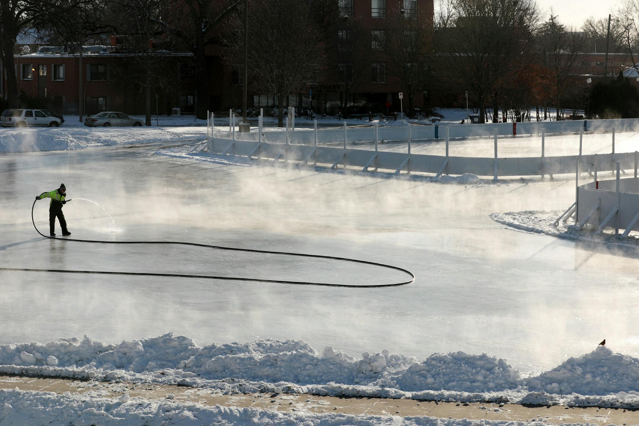 Jerry Earley, a park keeper with the Minneapolis Parks and Recreation maintenance department, sprayed water to form a rink as temperatures dipped below 0 Thursday.