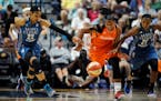 Minnesota Lynx' Maya Moore, left, and Renee Montgomery, right, pursue Connecticut Sun's Alyssa Thomas during the first half of a WNBA basketball game,