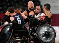 Charles Aoki of the United States, second right holds the ball under pressure from Zak Madell of Canada, rear, during a Wheelchair Rugby pool phase gr