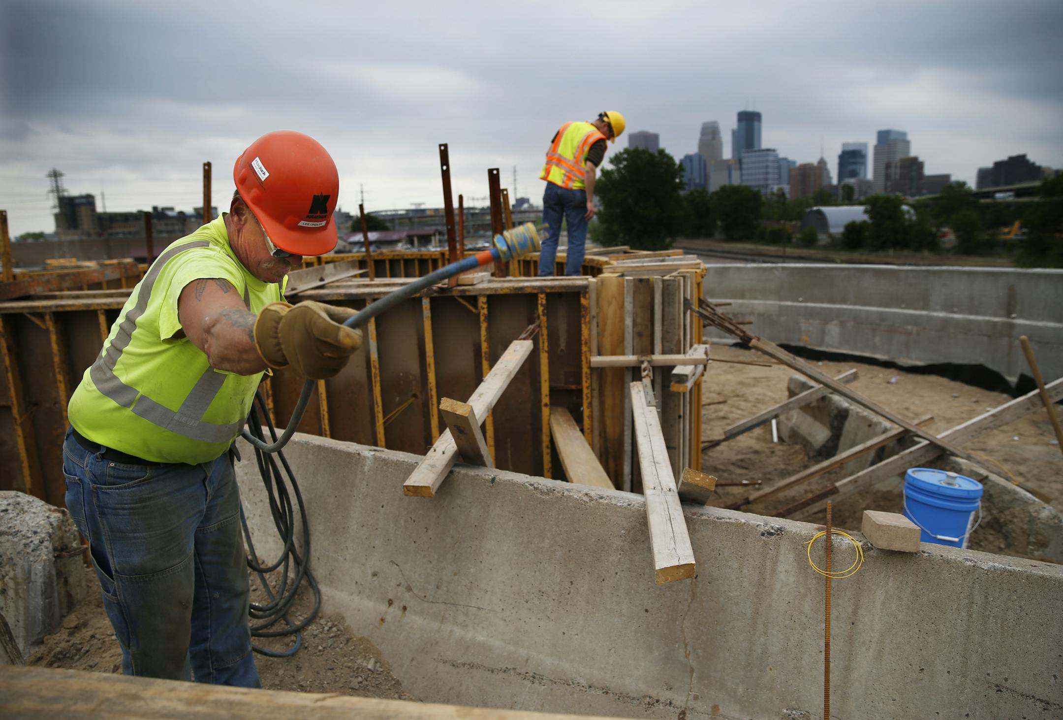 At the new Van Memorial Bridge on the North side of Minneapolis, construction workers including Lee Ondler put away an electric cable after helping build molds for a plaza with a view of downtown. The route will connect isolated pockets of the city. ] richard tsong-taatarii@startribune.com
