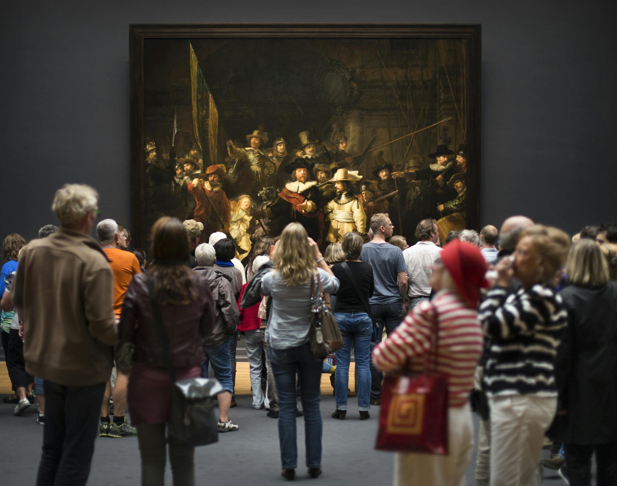 Visitors look at ‚ÄúThe Night Watch,‚Äù by Rembrandt, at the the Rijksmuseum in Amsterdam, Sept. 13, 2013. People visiting Amsterdam will find that some of the memories or ghosts of historic names, like Karl Marx, Vincent van Gogh, Rembrandt van Rijn and Anne Frank, some of whom have never lived in the city, are perennially passing through, eternally re-enacting a moment they spent there in life. (Ilvy Njiokiktjien/The New York Times) -- PHOTO MOVED IN ADVANCE A