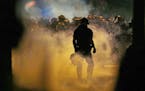 Police fire teargas as protestors converge on downtown following Tuesday's police shooting of Keith Lamont Scott in Charlotte, N.C., Wednesday, Sept. 