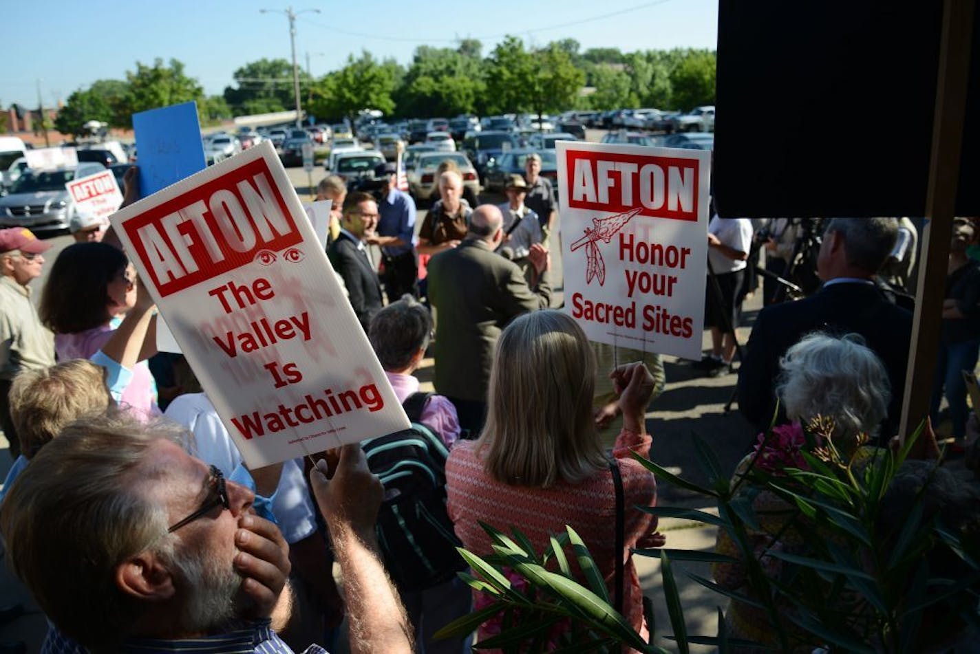 People hold signs during a news conference outside the Minnesota Pollution Control Agency ahead of the final Citizens' Board meeting in St. Paul on Tuesday.