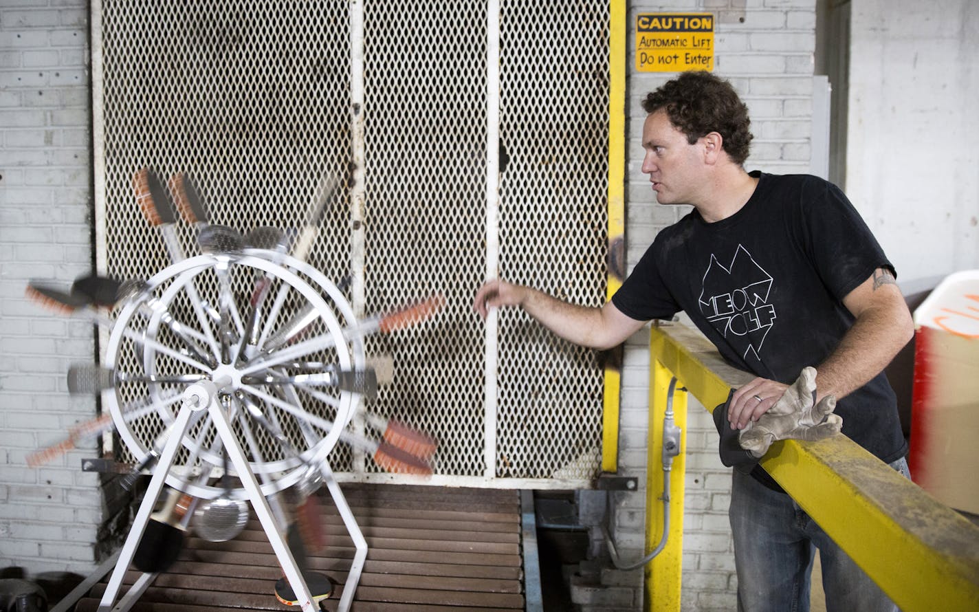 Chris Pennington, the creative director for Can Can Wonderland, plays with another wacky donation from Target, a spinning wheel made from kitchen spatulas and ping pong paddles. ] (Leila Navidi/Star Tribune) leila.navidi@startribune.com BACKGROUND INFORMATION: Thursday, June 16, 2106 in St. Paul. Can Can Wonderland is a massive indoor mini golf course slated for the old American Can factory in St. Paul's Midway neighborhood.