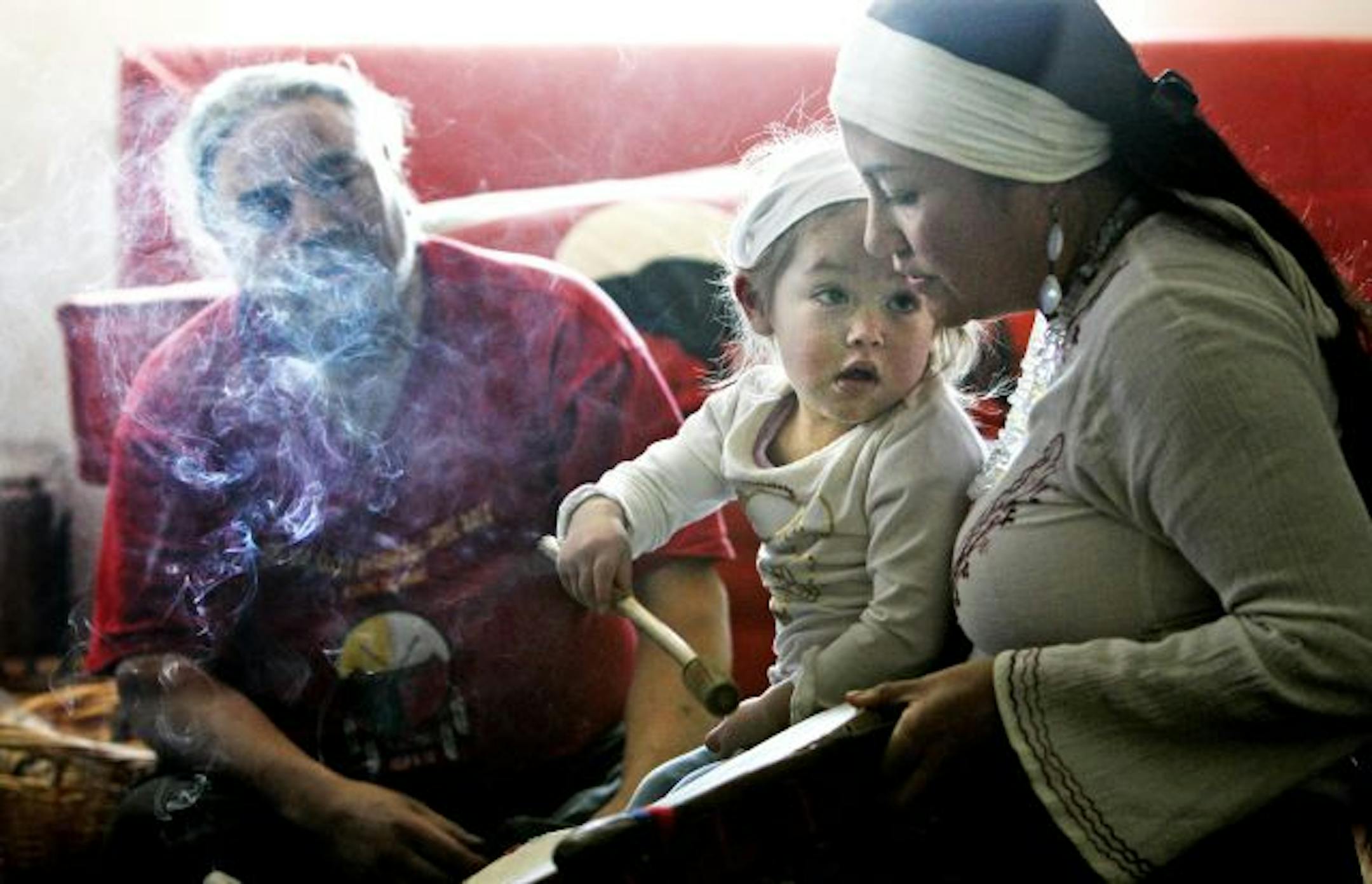 As part of the family's daily native prayers, Jim Anderson and his wife Claudia, who is of indigenous Mexican descent, and their daughter Ameyalli, 2, pray, drum and sing as smoke from burning sage drifts through their living room. Sage is considered a sacred plant and they sit on a buffalo hide during prayers.