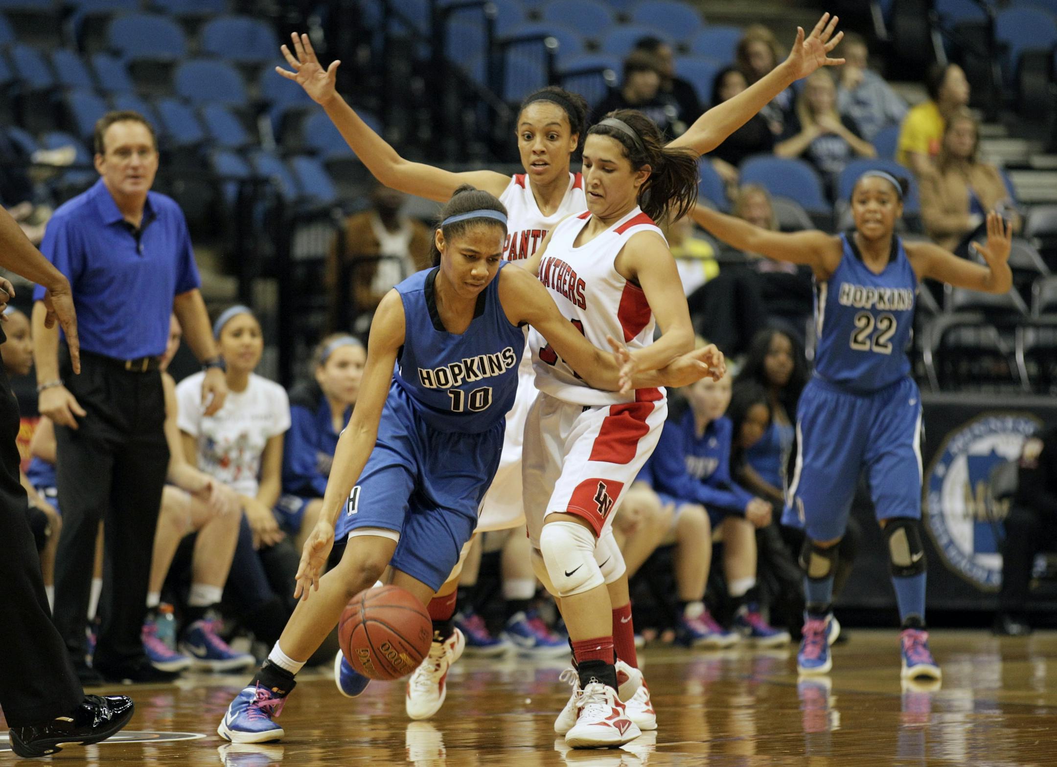 Lakeville North's Simone kolander (left) and Amanda Goodman try to defend Hopkins' Nia Coffey in the second half of the quarterfinal game at the girls' state basketball March 14 at Target Center.