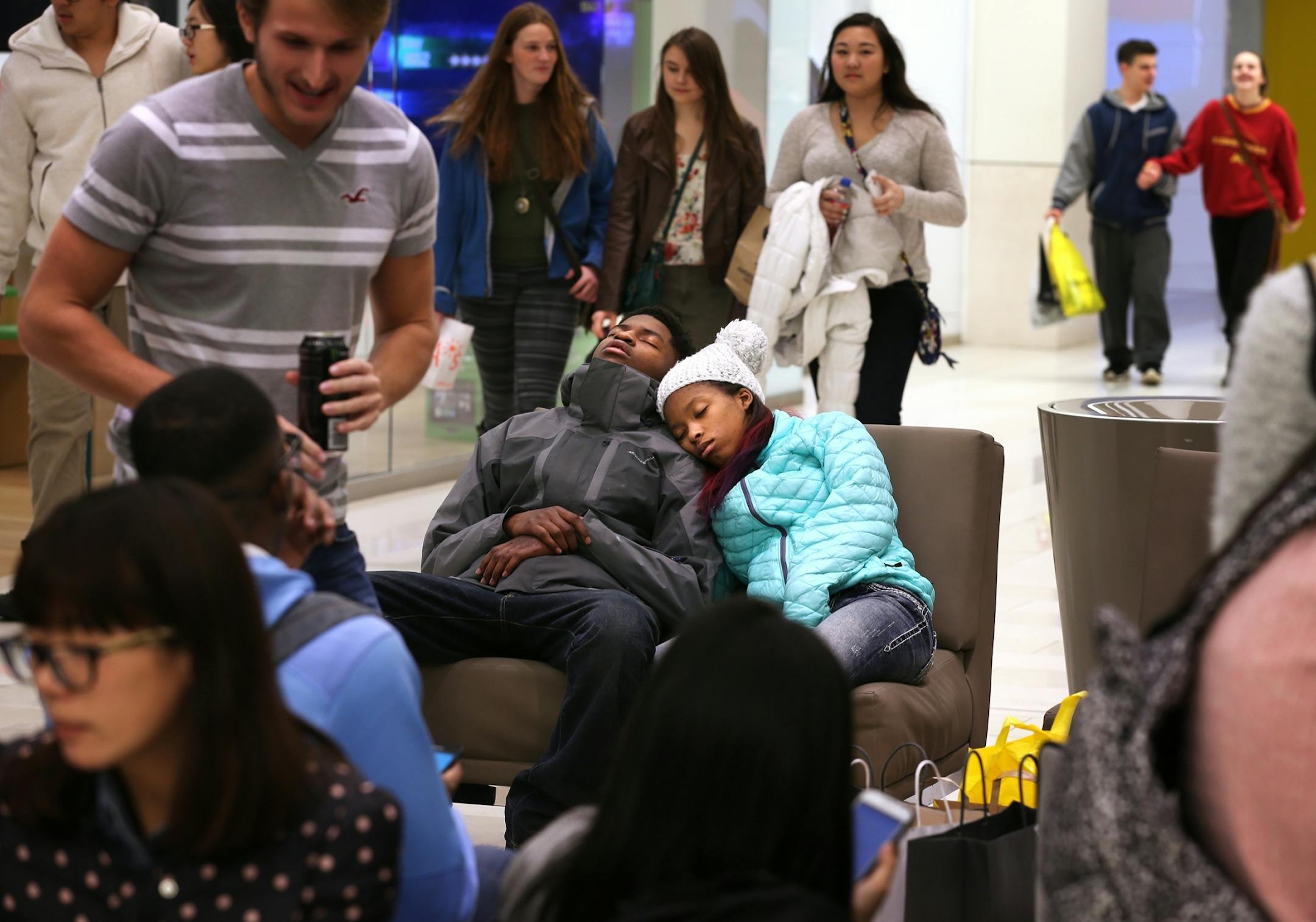 Tiyana Jordan, 14, of Columbia Heights, and Curtis Fortune, 18, of St. Louis Park take a nap together on Black Friday at Mall of America in Bloomington in the early morning on Friday, November 28, 2014. They had been shopping since midnight the night before.