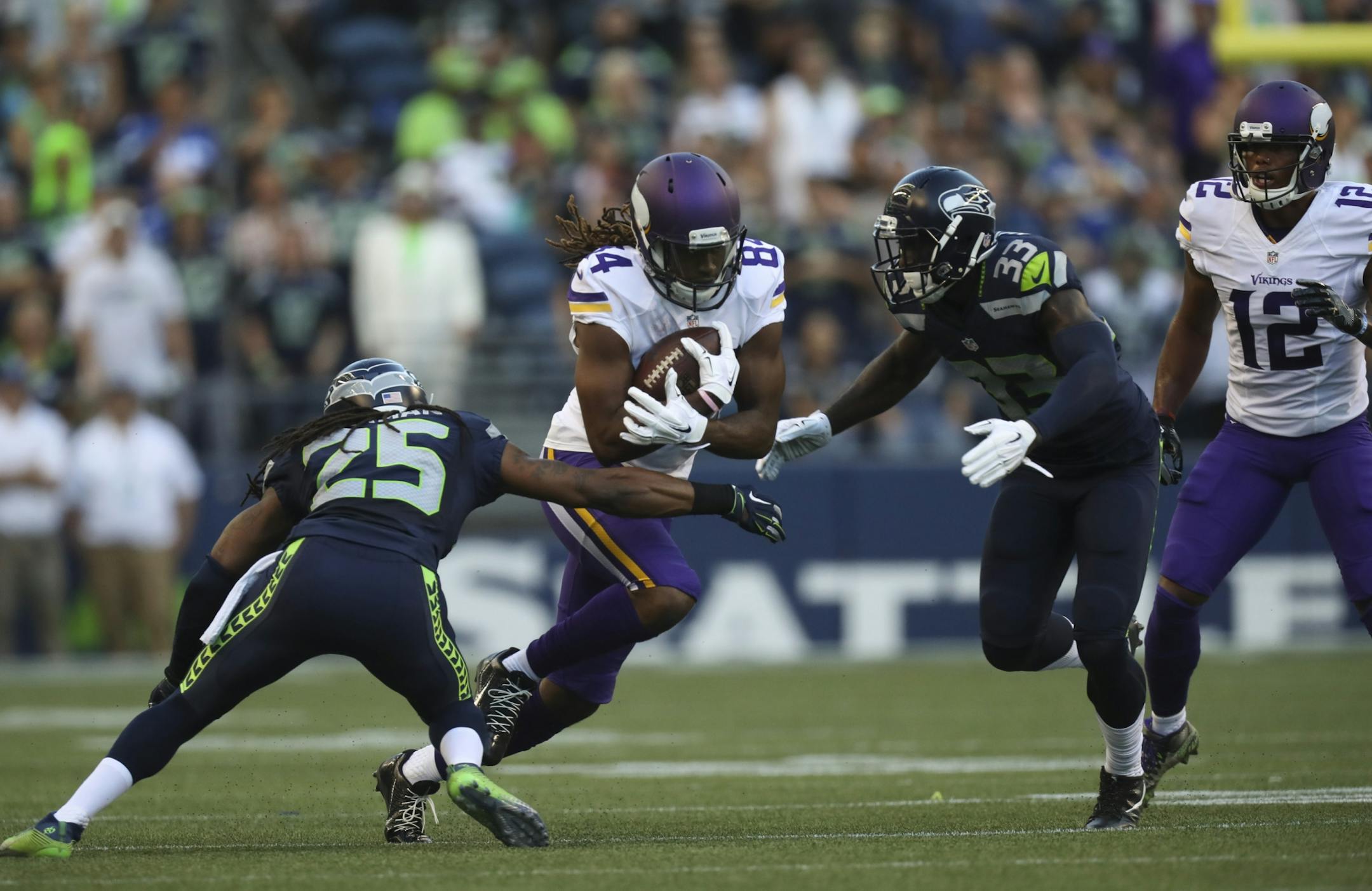 Vikings wide receiver Cordarrelle Patterson (84) caught a pass for a five yard gain before being stopped by Seahawks cornerback Richard Sherman (25) and strong safety Kelcie McCray (33) during the Vikings' first drive in the first quarter Thursday night.