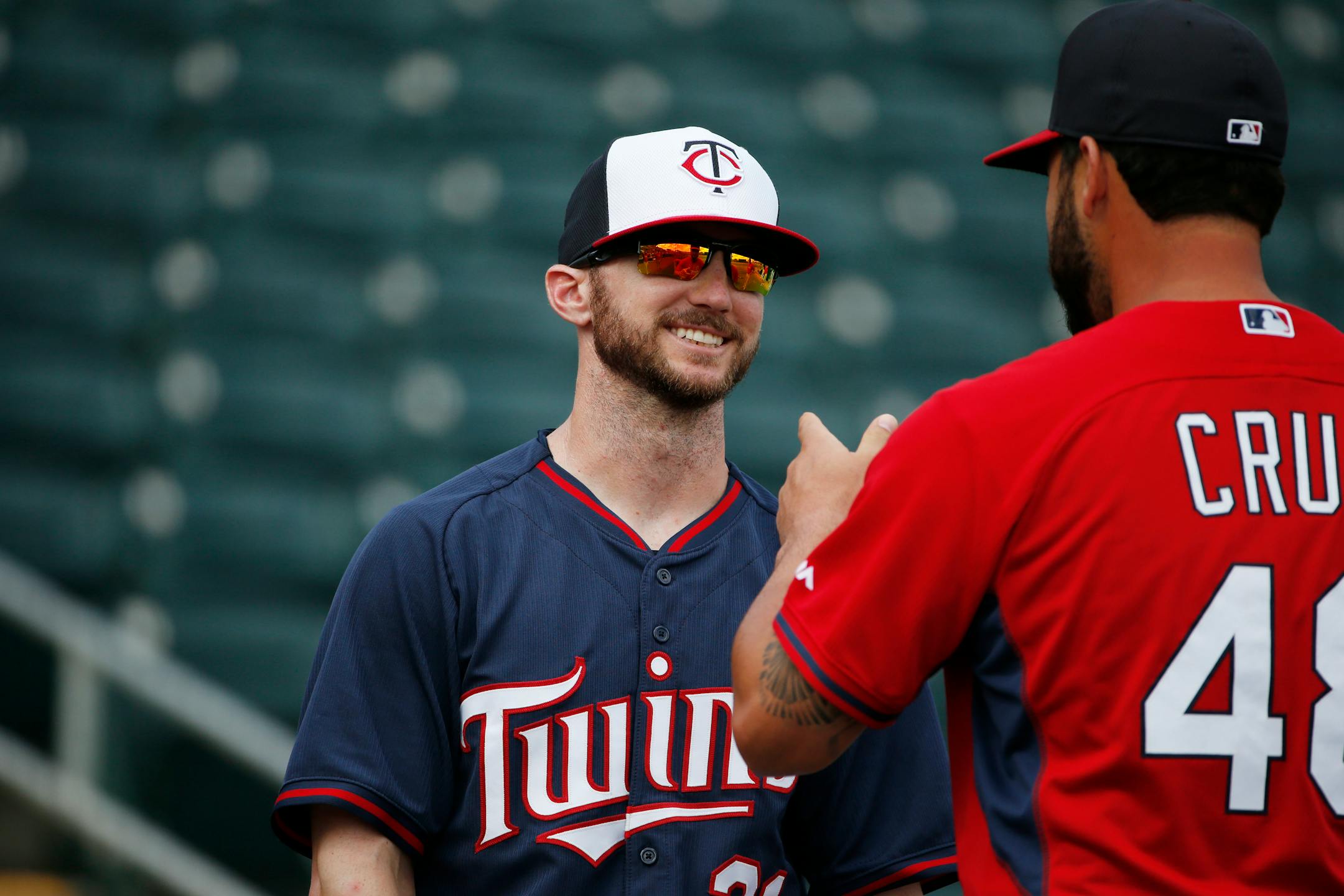 Minnesota Twins right fielder Shane Robinson (21) and St. Louis Cardinals catcher Tony Cruz (48) talk before an exhibition spring training baseball game, Sunday, March 15, 2015, in Fort Myers, Fla. (AP Photo/Brynn Anderson)
