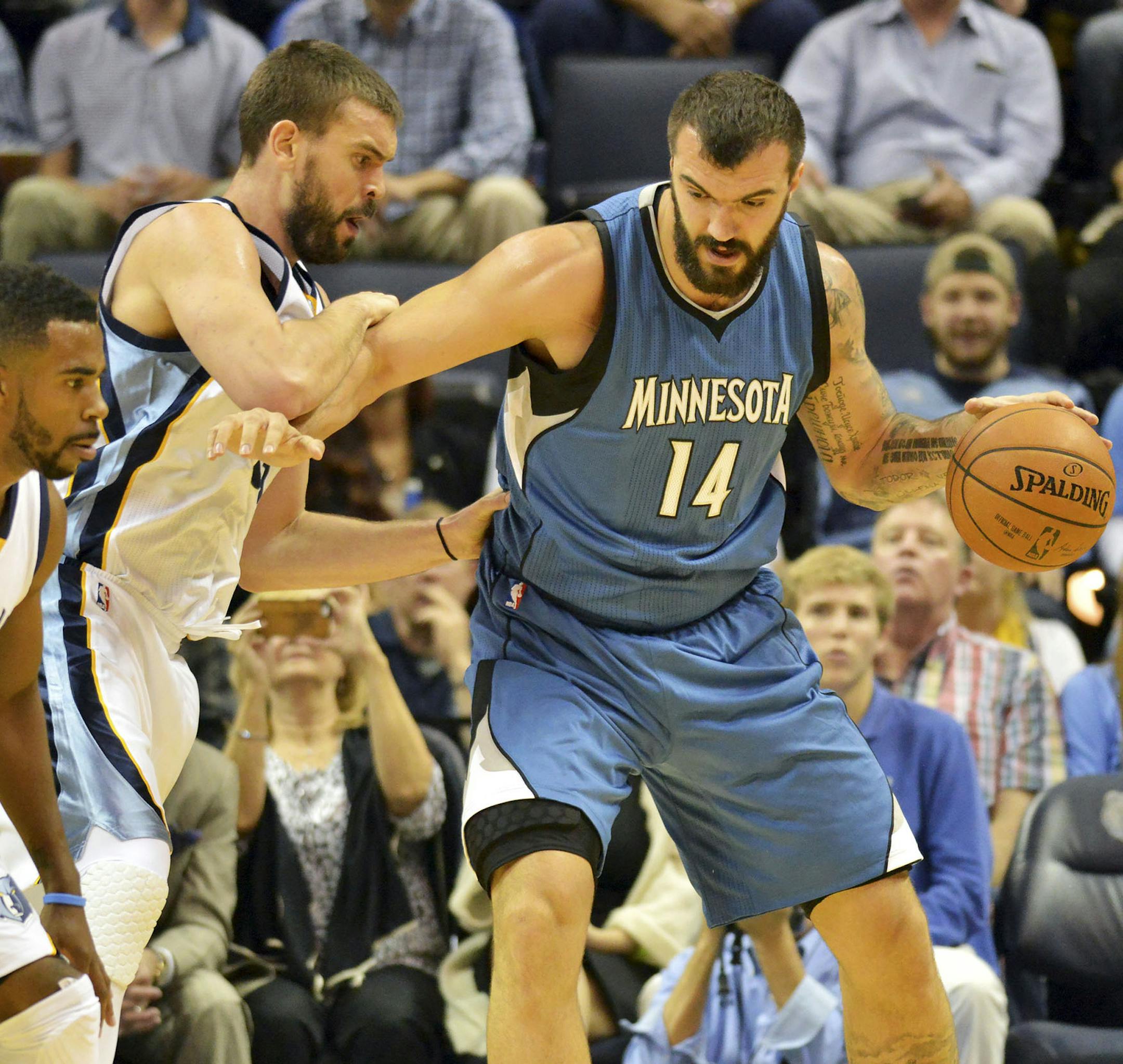 Minnesota Timberwolves center Nikola Pekovic (14) dribbles against Memphis Grizzlies center Marc Gasol, center, and Memphis Grizzlies guard Mike Conley (11) in the first half of an NBA basketball game Wednesday, Oct. 29, 2014, in Memphis, Tenn. (AP Photo/Brandon Dill)