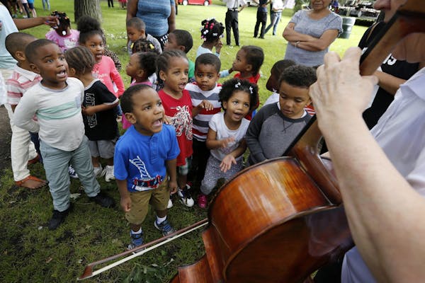 Children from Agape Early Learning Child Development Center sing "Old MacDonald Had a Farm" accompanied by cellist Faith Farr of Minnesota Sinfonia at