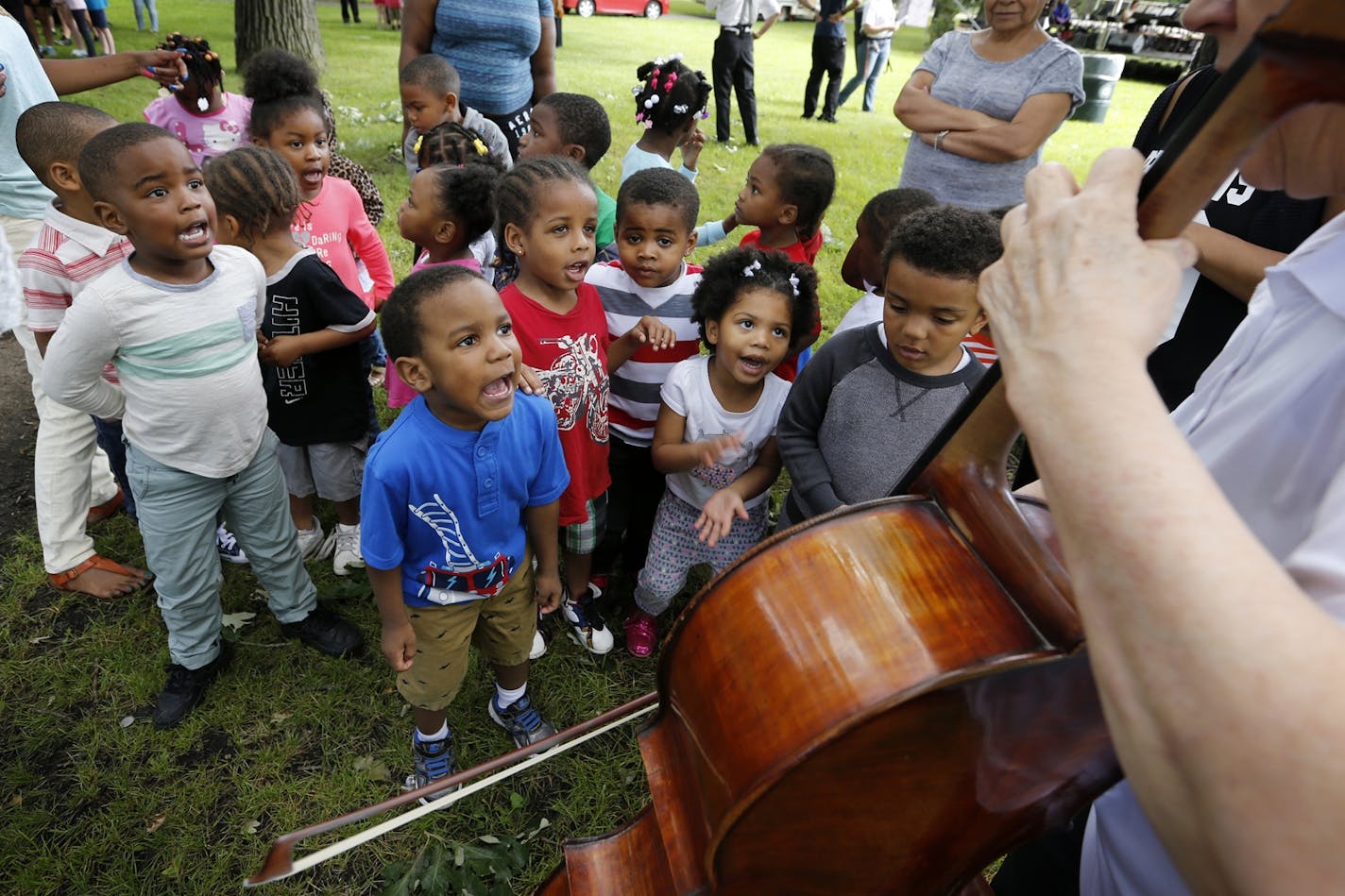 Children from Agape Early Learning Child Development Center sing "Old MacDonald Had a Farm" accompanied by cellist Faith Farr of Minnesota Sinfonia at Webber Park in north Minneapolis.