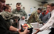 From the left, Brad Rixmann, Spc. Deanna Rice and Sgt. Banshee Barnett, Spc. Richard Polson and others packed boxes of gifts for soldiers overseas.