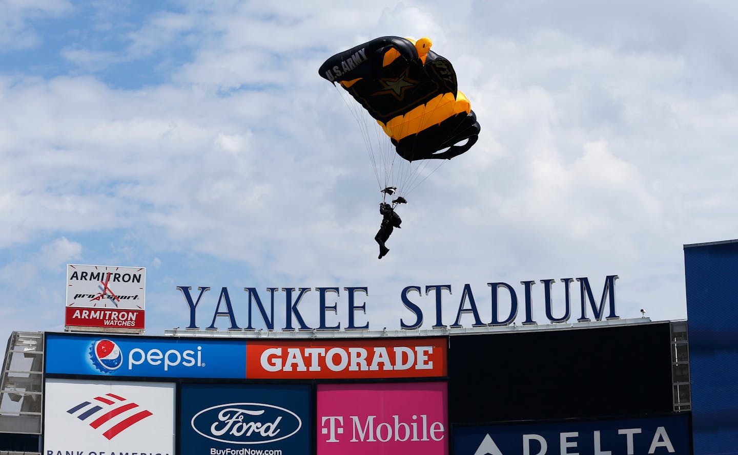 Members of the U.S. Army Golden Knights parachute into Yankee Stadium before a baseball game between the Toronto Blue Jays and the New York Yankees. Saturday, Aug. 20, 2022, in New York. (AP Photo/Noah K. Murray)