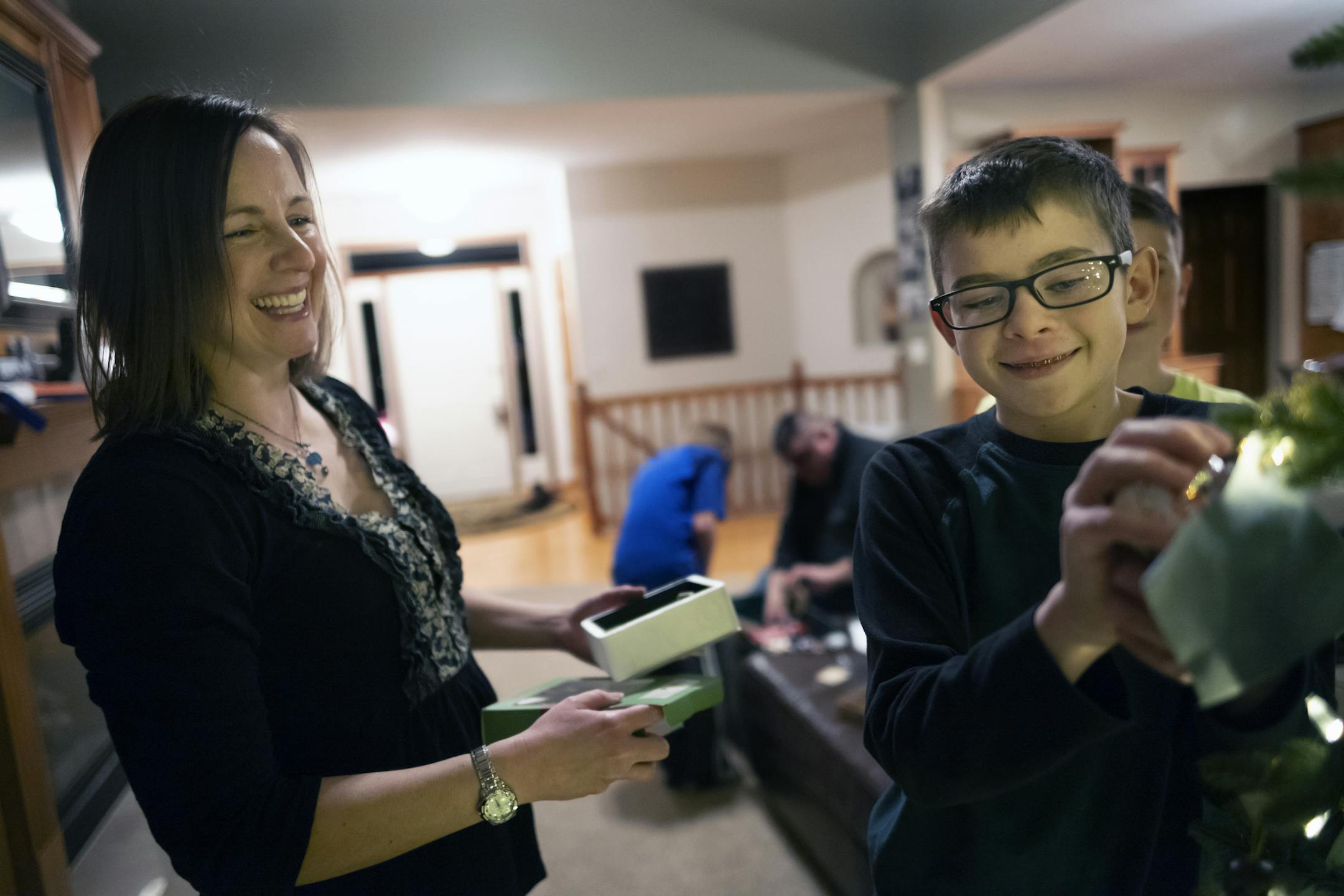 Sherri Taggart helps her son Jack, 14, hang some Christmas lights. Jack is recovering from leukemia and the family has received help from the Pinky Swear Foundation, which assists families with children with cancer.
