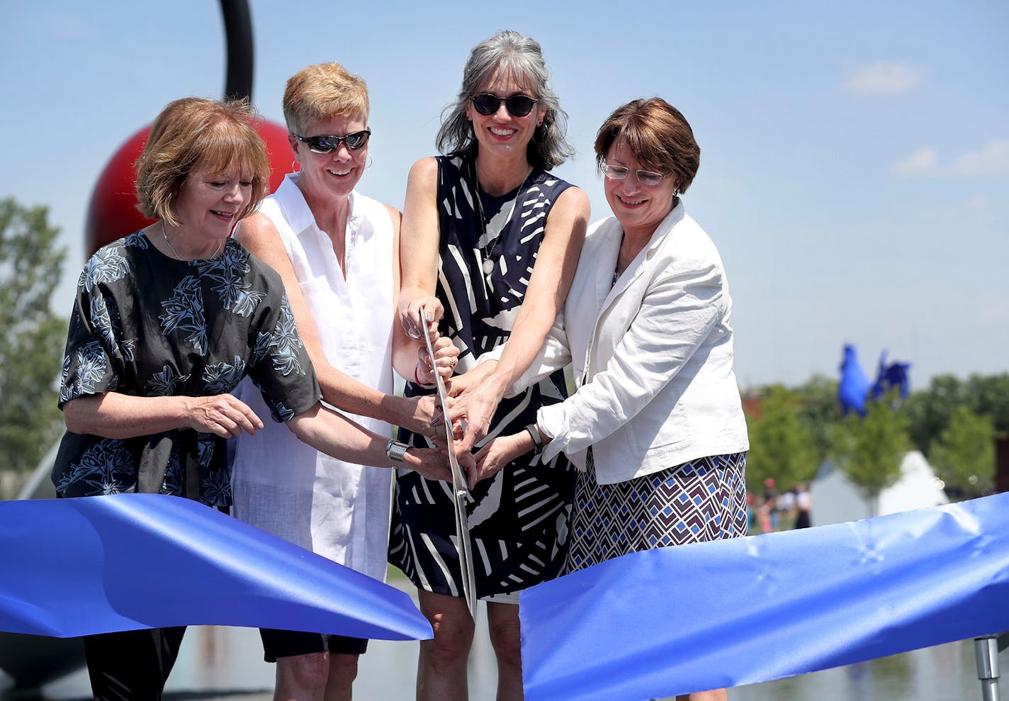 Olga Viso, with Lt. Gov. Tina Smith, left, Minneapolis Parks superintendent Jayne Miller and Sen. Amy Klobuchar, cut the ribbon to re-open the Minneapolis Sculpture Garden June 10, 2017.