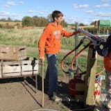 Spencer Muhonen, an employee of Apple Jack Orchards, loaded an apple into the orchard's apple canon Saturday. The orchard features activities for visitors beyond the traditional apple picking.