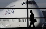 FILE - In this Jan. 21, 2010 file photo, a passenger walks past a Delta Airlines 747 aircraft in McNamara Terminal at Detroit Metropolitan Wayne Count