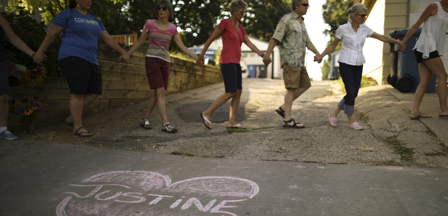 Friends and neighbors of Justine Damond held hands as a vigil to remember began Sunday evening. ] JEFF WHEELER &#xef; jeff.wheeler@startribune.com At least 250 people attended a vigil held Sunday evening, July 16, 2017 on W. 51st St. between Washburn and Xerxes, near where an Australian woman was shot and killed by Minneapolis Police Saturday night. ORG XMIT: MIN1707161933342404