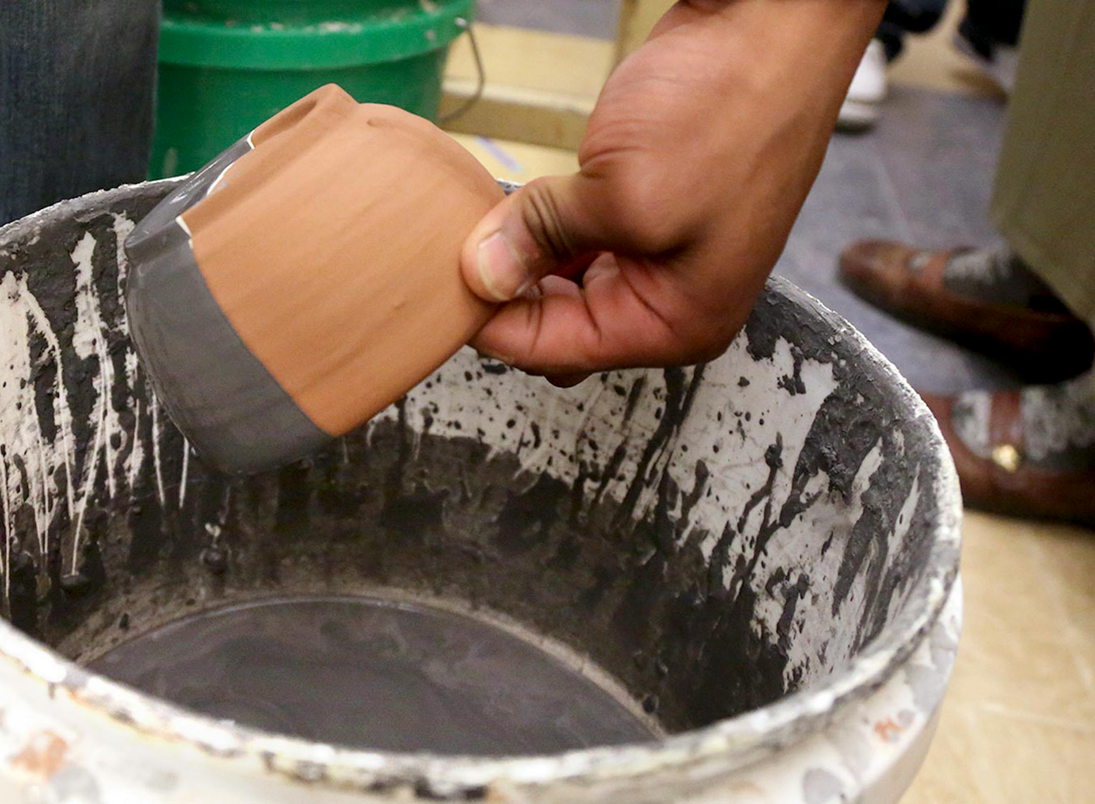 Edison High 10th grader Robert Hampton glazes a bowl for the Empty Bowls fundraiser at Edison High School Thursday, April 13, 2017, in Minneapolis, MN. "It's a good thing helping out our community," Hampton said, adding "it's a good way to keep people busy."