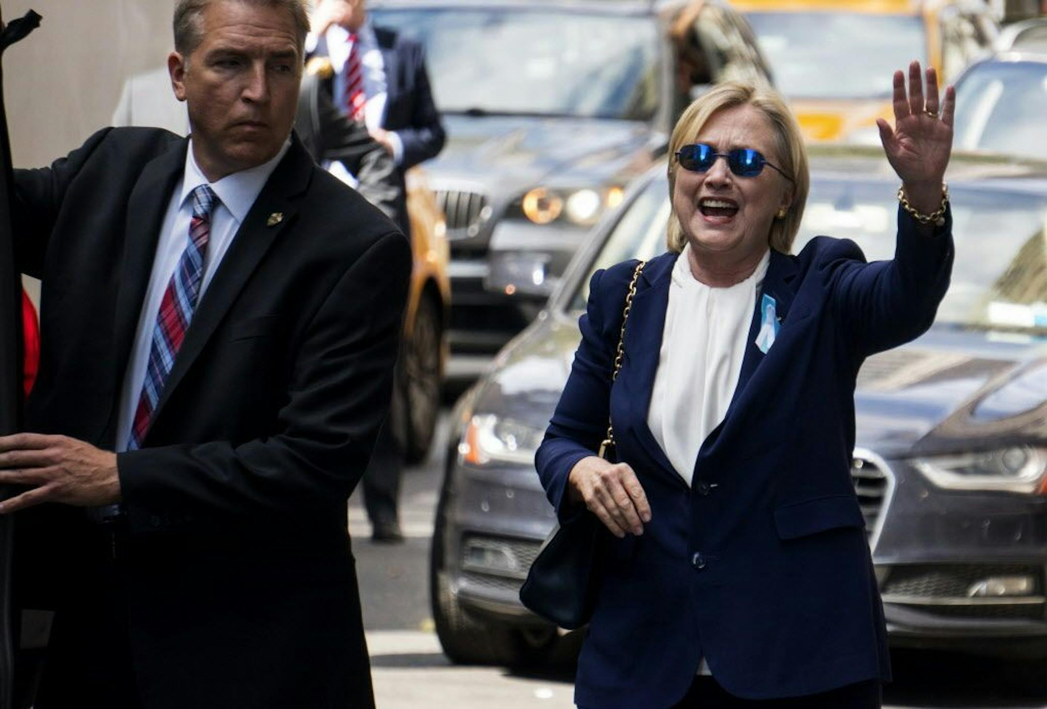 Democratic presidential candidate Hillary Clinton waves as she walks from her daughter's apartment building Sunday, Sept. 11, 2016, in New York. Clinton unexpectedly left Sunday's 9/11 anniversary ceremony in New York after feeling "overheated," according to her campaign.