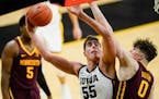 Iowa center Luka Garza (55) drives to the basket over Minnesota center Liam Robbins (0) during the second half of an NCAA college basketball game, Sun