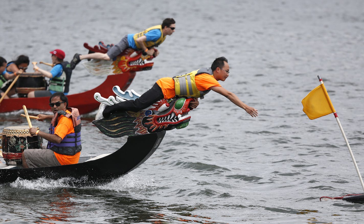 The MnDOT Snow Dragon James Xiong reached out to grab the flag first as his team raced Ameriprise Navigators on Lake Phalen. ] (KYNDELL HARKNESS/STAR TRIBUNE) kyndell.harkness@startribune.com Dragon Festival in St Paul, Min., Saturday, July 10, 2015.