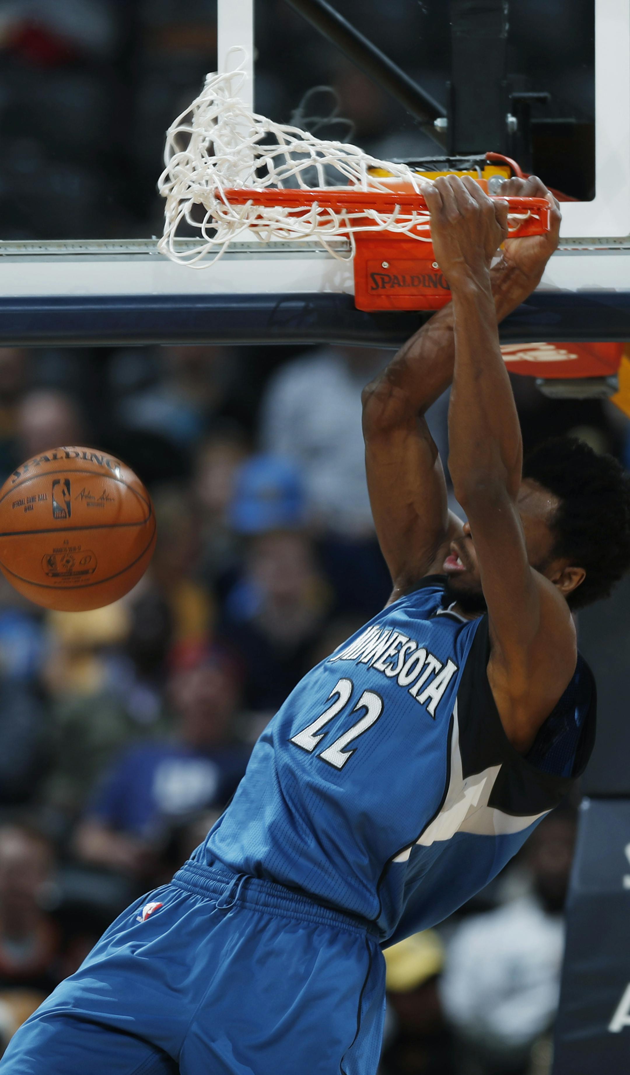 Minnesota Timberwolves forward Andrew Wiggins hangs on the rim after dunking the ball for a basket against the Denver Nuggets late in the second half of an NBA basketball game, Wednesday, Feb. 15, 2017, in Denver. The Timberwolves won 112-99. (AP Photo/David Zalubowski)