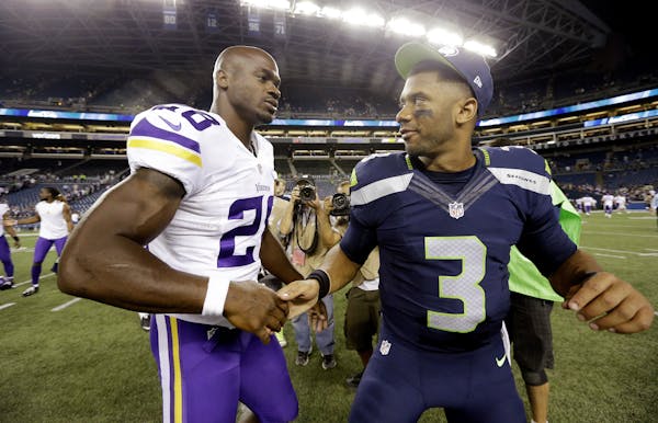 Seattle Seahawks quarterback Russell Wilson (3) is greeted by Minnesota Vikings' Adrian Peterson after a preseason NFL football game, Thursday, Aug. 1