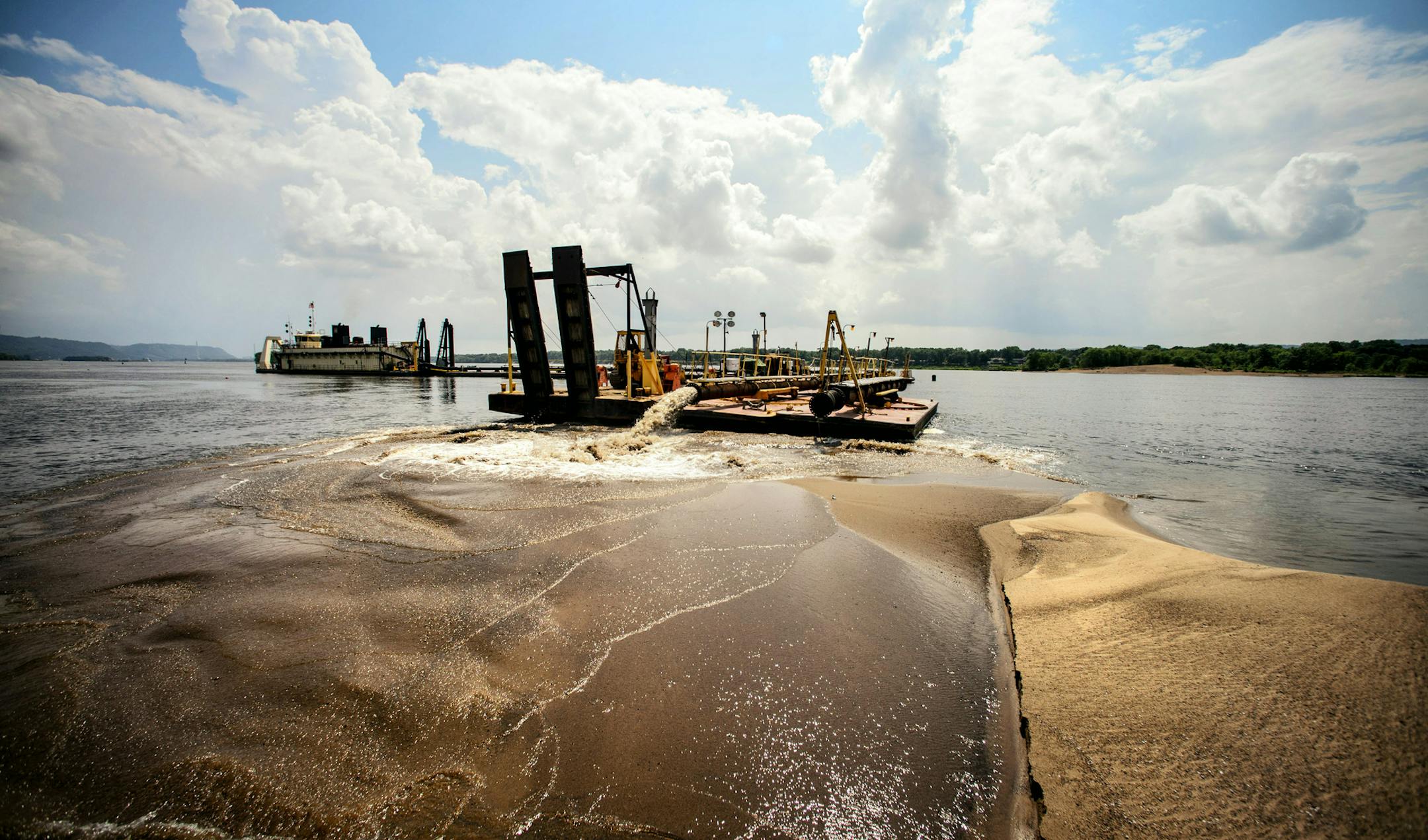 This dredge cuts a 200 foot swath into the navigation channel, insuring a 12-foot deep channel. The sand is dumped on the edge of the channel and will be removed later after safe navigation is restored. Barge and towboat traffic on the Upper Mississippi River is at a standstill after the navigation channel -- through which about half of the nation's grain exports pass -- became clogged with sediment from floodwaters this year, the same floodwaters that delayed the start of the shipping season by