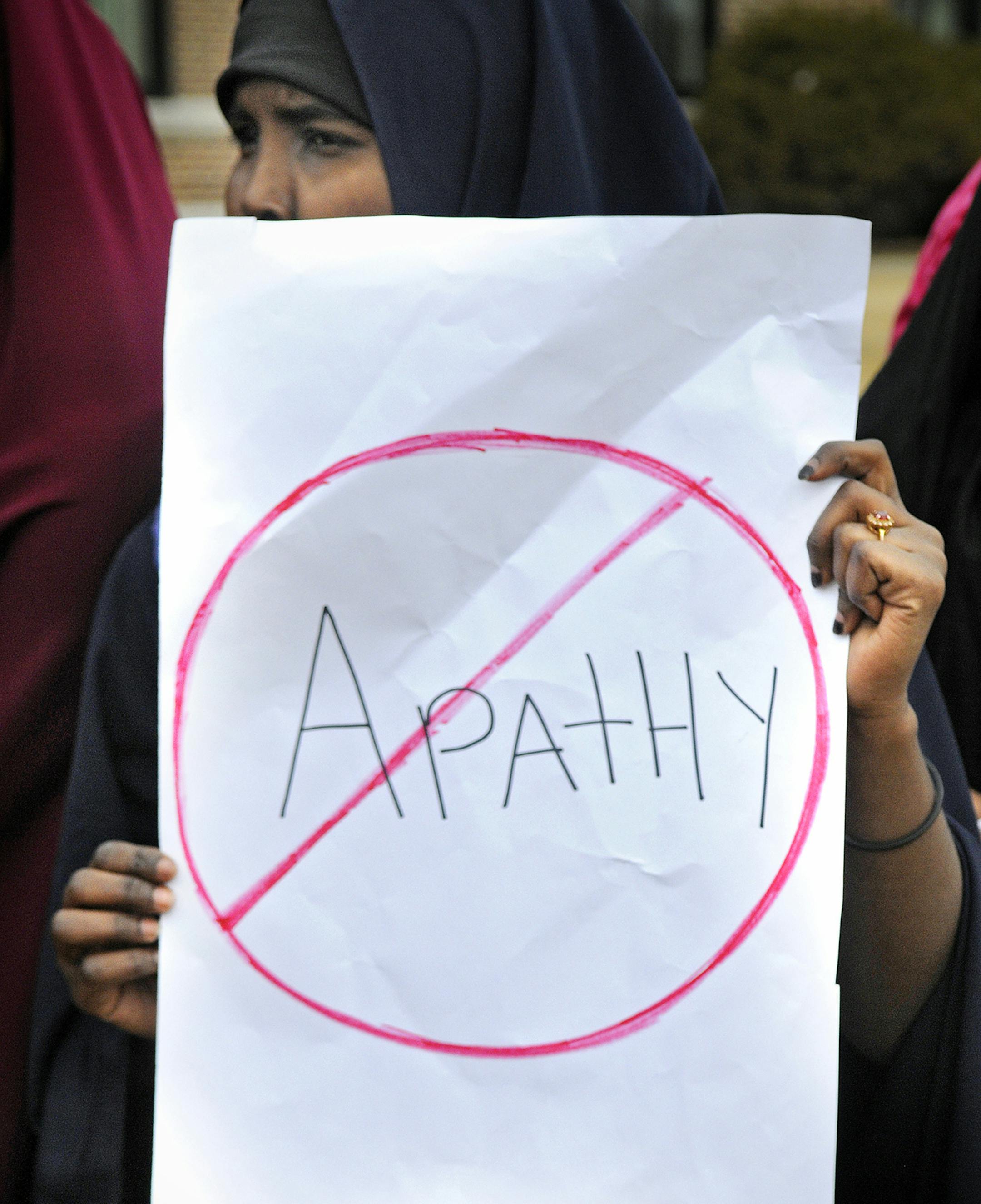 A protestor holds a sign in front of St. Cloud Technical High School Wednesday, March 18, 2015 in St. Cloud, Minn., during a demonstration against recent social media racial slurs against students. (AP Photo/The St. Cloud Times, Dave Schwarz) ORG XMIT: MNCLO103