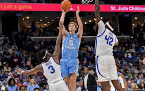 North Carolina guard Cade Tyson (5) shoots against Memphis' Colby Rogers (3) and center Dain Dainja during an exhibition game in October.